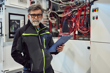 Experienced Electrical Engineer Examining Systems in a Modern Industrial Facility