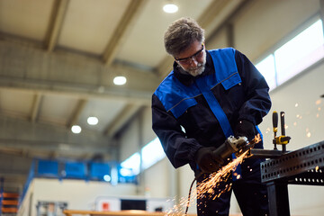 Industrial Worker Using Angle Grinder in Factory Workshop