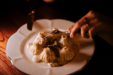 Dumplings on a plate with sauce being enjoyed at a cozy restaurant in the evening
