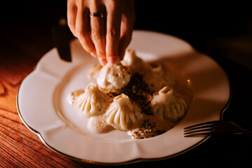 Enjoying homemade khinkali served with a creamy sauce in an inviting setting