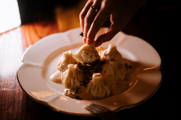 Enjoying delicious khinkali at a cozy restaurant during dinner time with friends