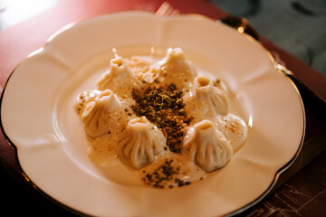 Traditional khinkali served on a decorative plate in a cozy restaurant setting