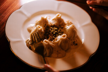 Delicious khinkali served with rich sauce captures the essence of Georgian cuisine in a cozy setting