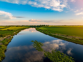 Aerial view of beautiful sunset in countryside with river and grain fields