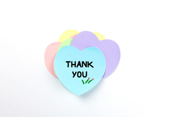 Top view, flat lay of a light blue heart-shaped sticky note with the words 