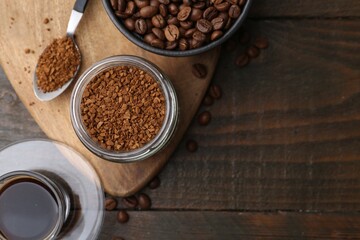 Instant coffee in glass jar, hot drink and beans on wooden table, flat lay. Space for text