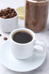 Aromatic hot drink, instant coffee and beans on white table, closeup