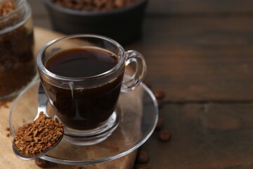 Aromatic hot drink, instant coffee and beans on wooden table, closeup. Space for text