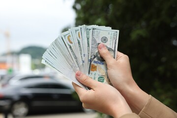 Woman counting her money outdoors, closeup view
