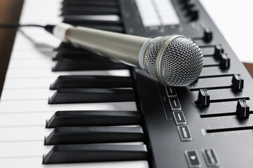 MIDI keyboard and microphone on table, closeup
