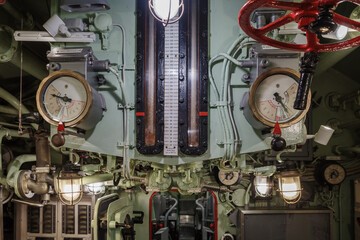 The complex and cramped interior of a vintage submarine's control or engine room, featuring an...