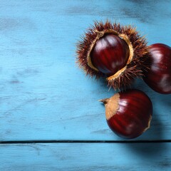 Close up of chestnuts on a vibrant blue wood texture, perfect for conveying a sense of autumn. The rich colors of the chestnuts provide a beautiful contrast against the textured background