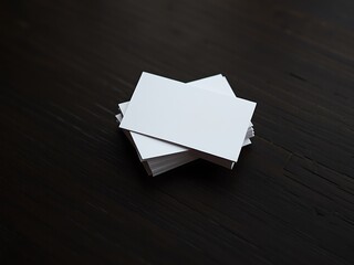 Blank white business cards stacked on a dark wooden surface ready for branding and design customization