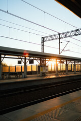 Vertical screen: soft dawn illumination filtering through architectural train station interior,...