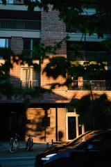 Vertical screen: sunlight illuminating brick facade of modern residential building at sunset with...