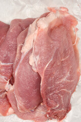 Fresh pieces of raw pork laid out on butcher paper