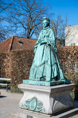 The statue of Queen Caroline Amalie stands proudly in the serene Rosenborg Castle Garden,...
