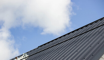 A man is installing solar panel mounts on the roof. Selective focus