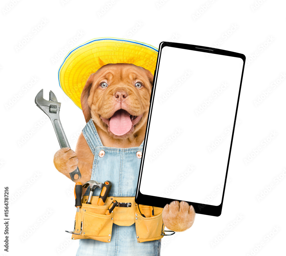 Poster funny mastiff puppy wearing summer hat and denim overalls with tool belt showing big smartphone with