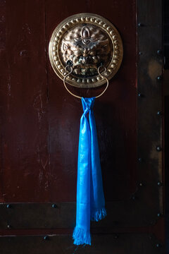 Mongolian lion door knocker with blue khadag scarf