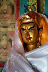 Statue of Padmasambhava draped in ceremonial silk scarf inside Buddhist temple in Mongolia