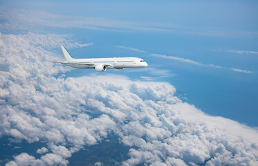 White passenger airplane flying in the sky amazing clouds in the background - Travel by air...