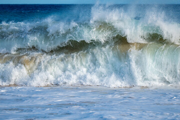 A towering wave curls like oceanic jaws ready to snap shut, capturing the raw menace and beauty of coastal high surf in a single ferocious moment.