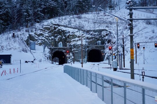 Two paralell tunnels pass through hard grey rock at the north end of the platform at Dombaas train station in Dombaas, Norway.
