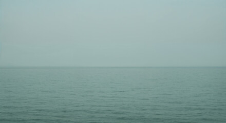 Obraz premium Minimalist Seascape: Calm Ocean Under a Gray Sky