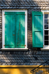 Verwitterte grüne Fensterläden an einem mit Schiefer verkleideten Haus  in Wuppertal, Deutschland