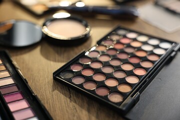 Different makeup products on wooden table, closeup