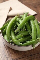 Fresh ripe green peas on wooden table, closeup