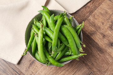 Fresh ripe green peas on wooden table, top view