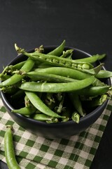 Fresh ripe green peas on black table, closeup