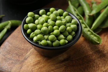 Fresh ripe green peas on black table, closeup