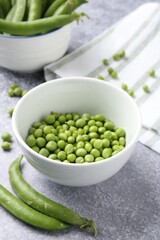 Fresh ripe green peas on grey table, closeup