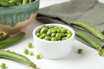 Fresh ripe green peas on white wooden table, closeup