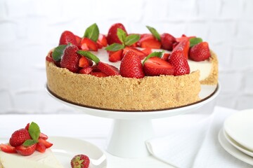 Delicious cheesecake with strawberries and mint on white table, closeup