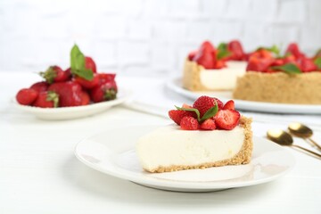 Piece of tasty cheesecake with strawberries and mint on white wooden table, closeup