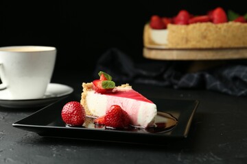 Piece of tasty cheesecake with strawberries, sauce, mint and coffee on black table, closeup
