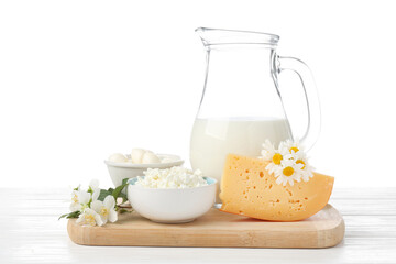 Different fresh dairy products and flowers on wooden table against white background