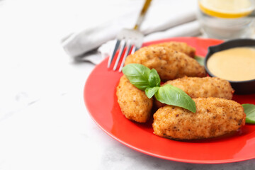 Tasty fried croquettes, basil and sauce on white marble table, closeup. Space for text