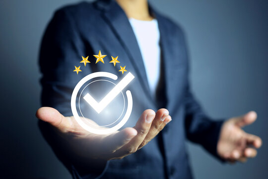 a man's hand holding five star certification with check mark means that has been certified to a quality standard or has passed an audit according to industry standards