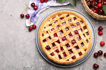 Tasty cherry pie and berries on grey textured table, flat lay