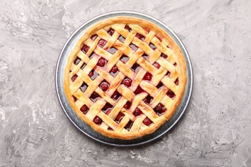Tasty cherry pie on grey textured table, top view