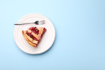 Piece of tasty strawberry pie on light blue background, top view. Space for text