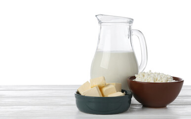 Different dairy products on wooden table against white background