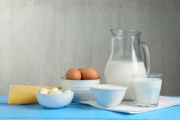 Different dairy products and eggs on light blue wooden table