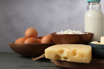 Different dairy products and eggs on grey wooden table, closeup