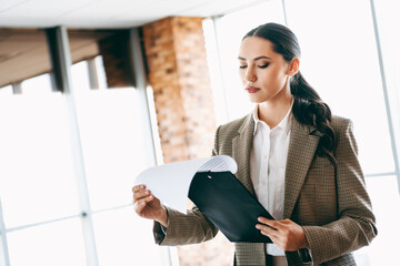 Professional Woman in an Office Reviewing Documents Focused on Career and Business Success